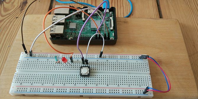 يتم توصيل Raspberry Pi بزر وزر LED على لوحة توصيل.