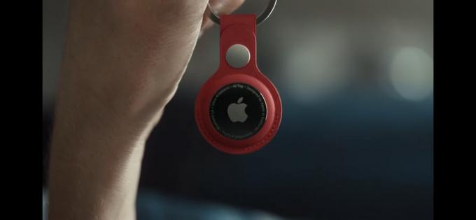 Apple AirTag على Red Keychain في متناول اليد.